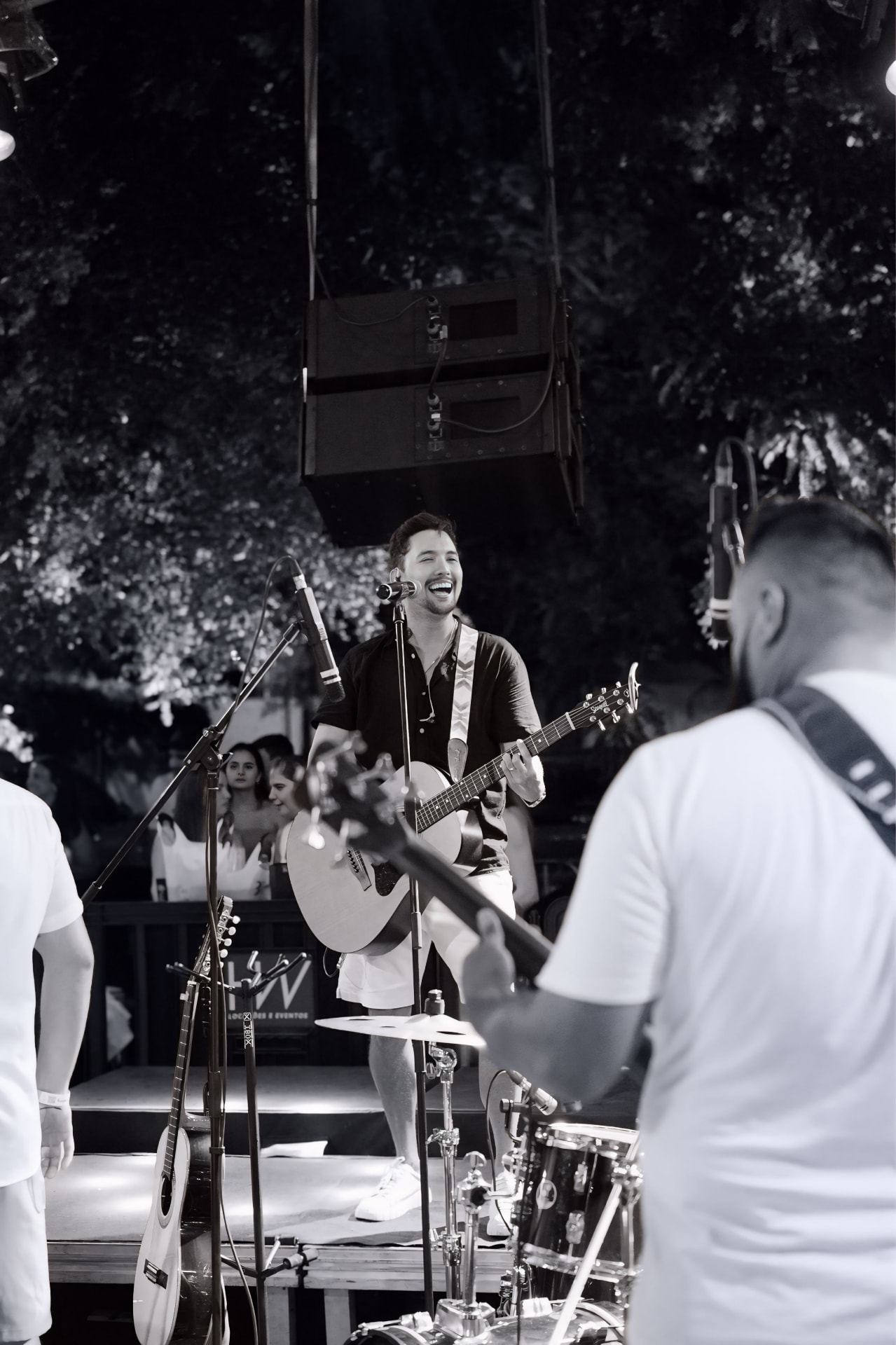 ÔPaulin cantando e tocando violão com a banda em preto e branco